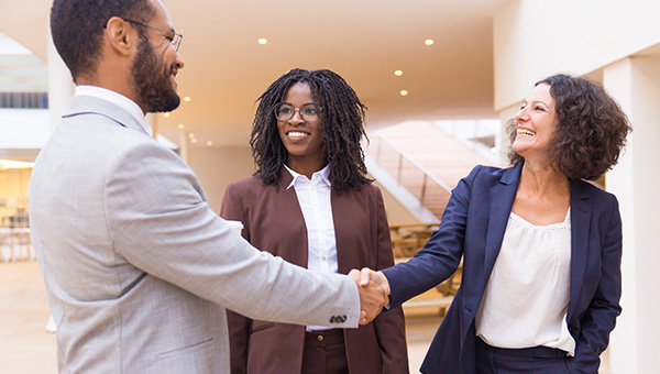 Man shaking hands with female lawyer who is representing him. 