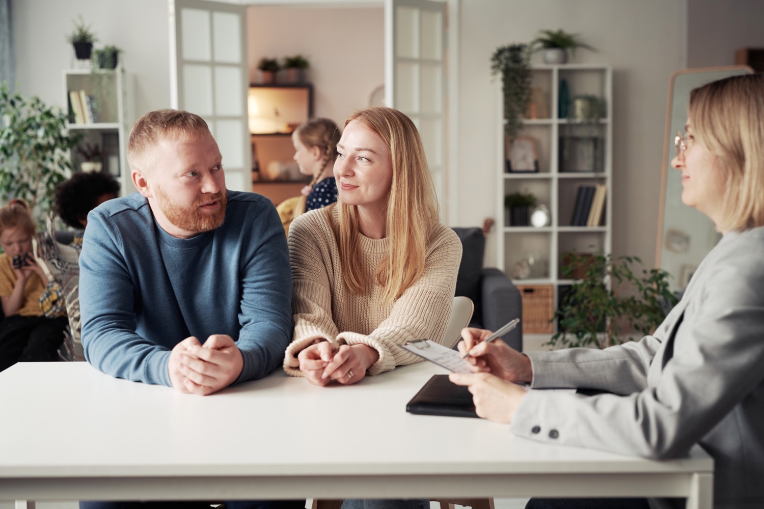 A young couple talks with a social worker about the requirements for adopting a child.